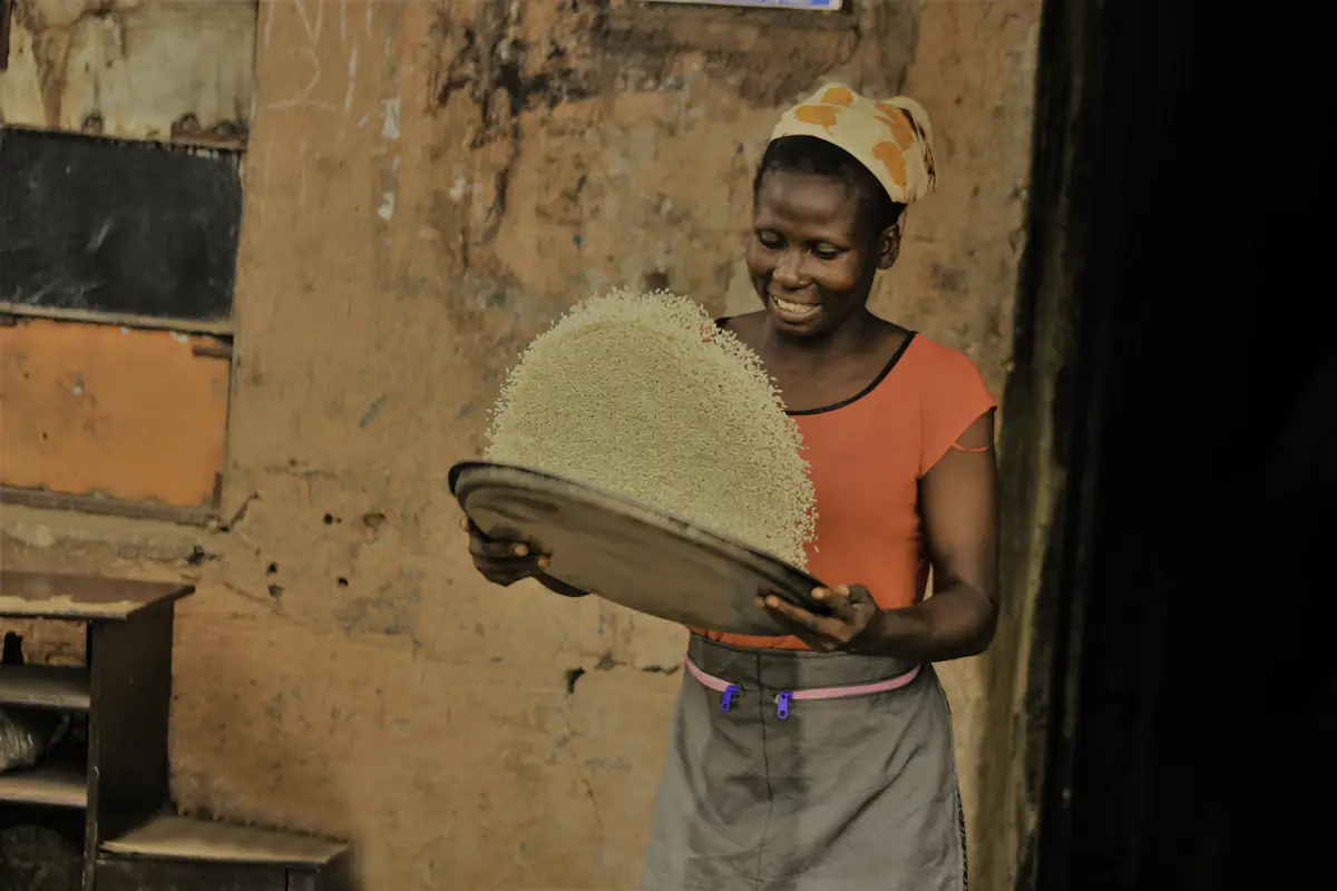 Une femme vanne des grains avec un plateau tressé