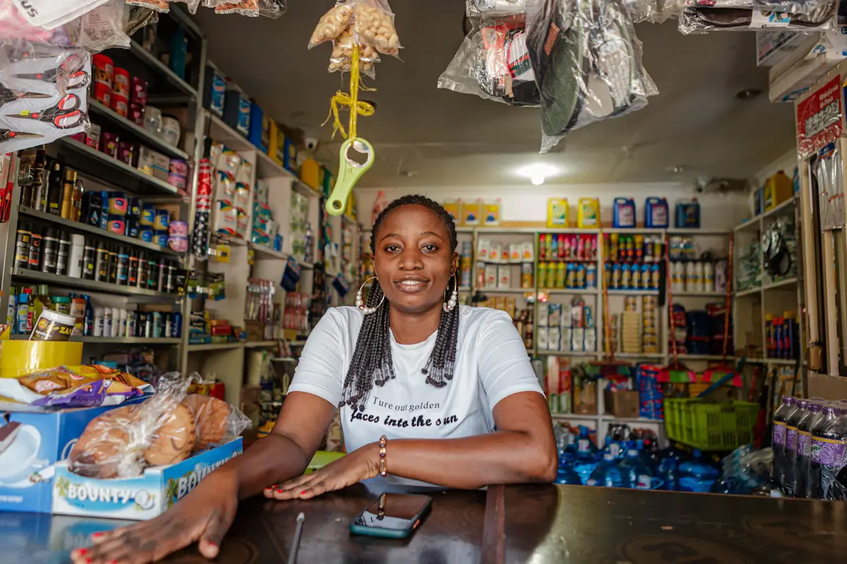Une commerçante souriante au comptoir de sa boutique
